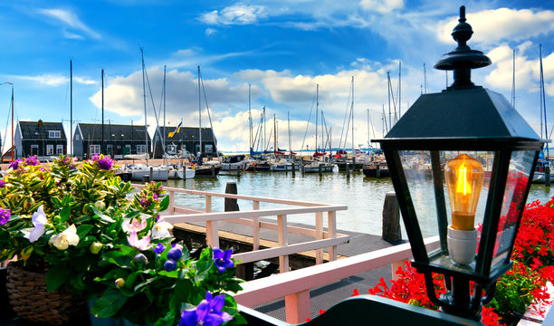 The harbor of Marken with flowers and lamp in foreground. Marken is a small historical dutch village in Netherlands