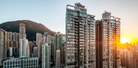 Fototapeta na wymiar sunsert sky over modern city skyline with residential skyscraper buildings in Hong Kong