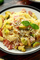 Homemade Brussels sprouts, bacon, pancetta pasta with parmesan cheese. On wooden table
