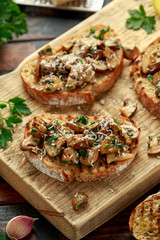 Grilled mushroom toast with parsley, lemon and parmesan cheese on wooden board. healthy vegan food