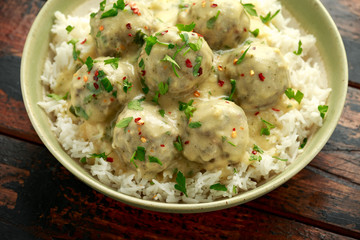 Hot Swedish meatballs with white rice on wooden table