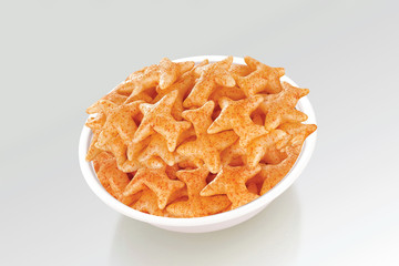 Fried and Spicy Aero Plane Snacks or Fryums (Snacks Pellets) served in a bowl or White background. selective focus - Image