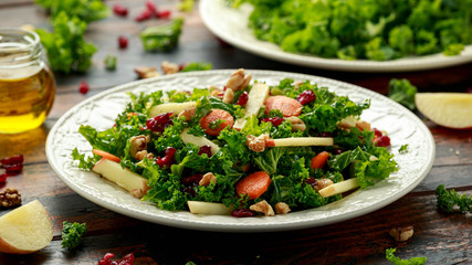 Kale salad with dried cranberry, carrots, walnuts and apple. healthy vegan food.