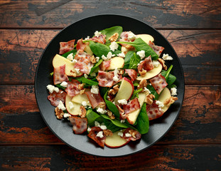 Bacon, Apple Salad with spinach, walnuts and feta cheese. on wooden table. healthy food.