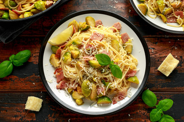 Homemade Brussels sprouts, bacon, pancetta pasta with parmesan cheese. On wooden table