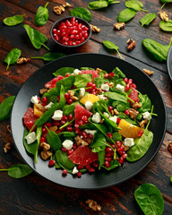 Orange Grapefruit salad with spinach, walnuts, pomegranate seeds and feta cheese. healthy food