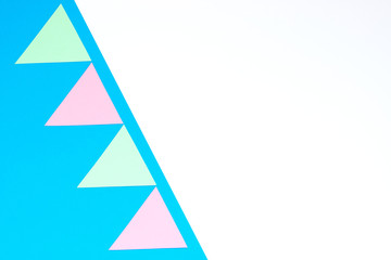 Colorful garland of paper triangles on a blue background. Greeting card. Flat lay style. Copyspace for text.