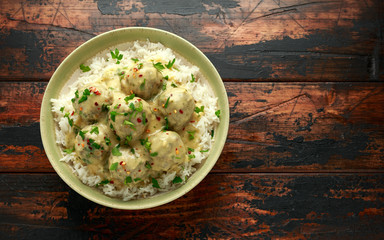 Hot Swedish meatballs with white rice on wooden table