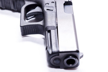 The muzzle of a black 9mm semi automatic pistol with a white background