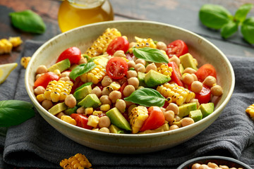 Avocado chickpea salad with grilled sweet corn, tomato and basil. Healthy vegan food