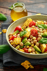 Avocado chickpea salad with grilled sweet corn, tomato and basil. Healthy vegan food
