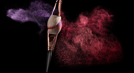 powder explosion with make-up brush on black ground