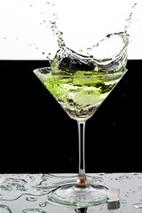 martini glass and splash from falling ice on a white background