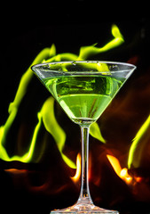 ice falls on a martini glass on a black background and lines of fire in the dark