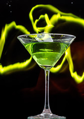 martini glass and splash from falling ice on a black background