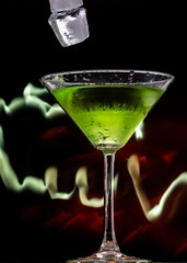 martini glass and splash from falling ice on a black background