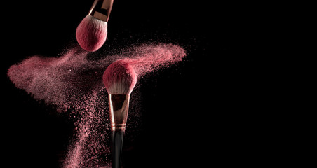 powder explosion with make-up brush on black ground