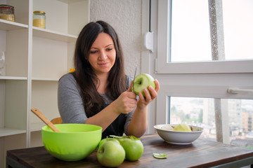 Woman peeling apples in the kitchen