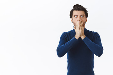 Shocked young man losing lots money, failed business meeting, hold hands on mouth, stare speechless...
