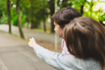 Young girl giving direction to senior woman outside