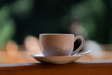 White cup of hot latte coffee isolated on nature background. Concept of food in fresh air. Overhead view, copy space. Advertising for cafe menu. Coffee shop menu. Horizontal photo.