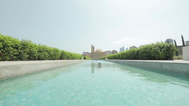 Taza Pir Mosque Baku. View of the mosque through the fountain. Summer sunny day. View of Baku through the natural landscape.