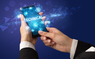 Female hand holding smartphone with TECHNICAL inscription, modern technology concept