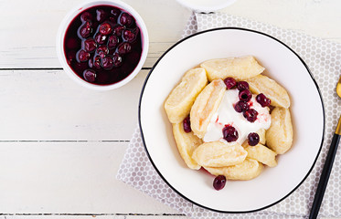 Traditional  ukrainian / russian cottage cheese lazy dumplings served with sour cream and cherry...
