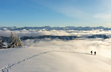 Hiker in snowy mountain landscape near Oberstaufen, Bavaria, Germany