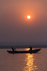 Cae el sol sobre una barca en el río Ganges 