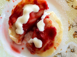 Top view on traditional Ukrainian desert - vareniky stuffed with cherry berry, flavored with cherry mash