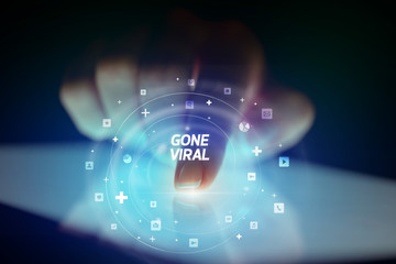 Finger touching tablet with social media icons and GONE VIRAL