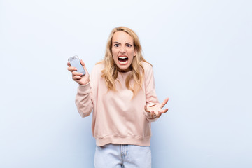 young blonde woman looking angry, annoyed and frustrated screaming wtf or what‚Äôs wrong with...