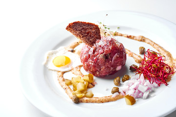 Tartare with egg. Set Food Menu On A White Plate. Top view of light dish perfect served.