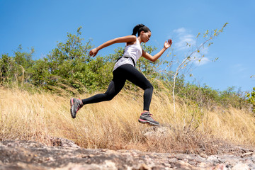 Young Black Woman Running and  Jumping at Forest Trail.
