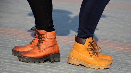 Girls in shoes, half-boots are standing on the sidewalk tiles, in a Sunny evening. A quarrel...