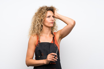 Young hairdresser woman over isolated background having doubts and with confuse face expression