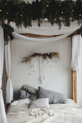 Modern home interior design. Bed with wooden canopy and pillows, blanket. Bedroom interior, scandinavian style. Home decor. 
