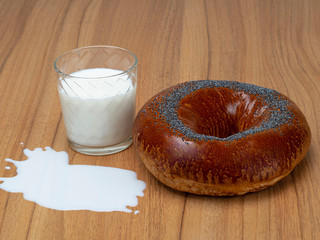 Fresh homemade Poppy bagel bread with glass of milk on the table. Rustic style