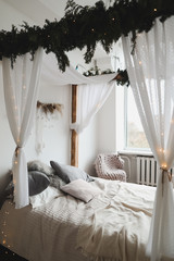 Modern home interior design. Bed with wooden canopy and pillows, blanket. Bedroom interior, scandinavian style. Home decor.  © paralisart