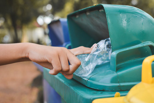 Cropped Hand Putting Plastic In Garbage Can