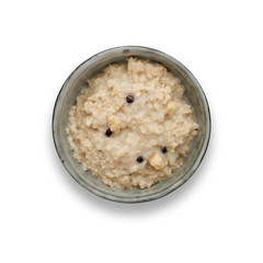 A bowl of nutritious blueberry and apple porridge isolated on white, shot from above