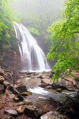 Waterfall flows in mountain forest