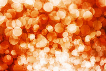 Party festive happy glitter texture. Orange bokeh shiny background. Abstract vibrant color glowing...