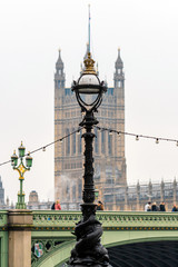 Obraz premium Dolphin lamp standard on Thames Embankment in London at the Westminster Bridge, bloored Westminster Abbey on background