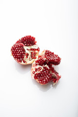 Ripe Pomegranates Fruit With Cut Open On White Background. Two halves of a torn pomegranate with...