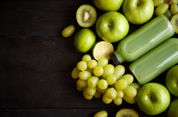 Mixed green fruits and vegetables placed on black wooden table