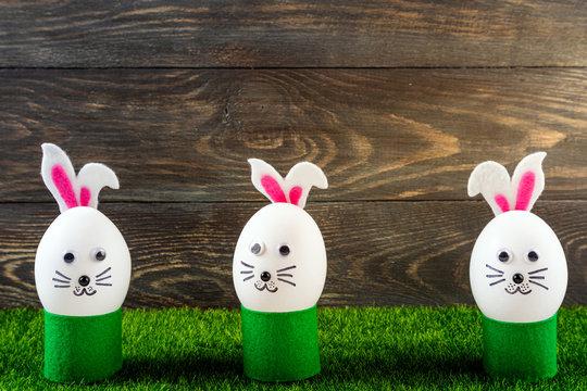 Happy Easter background. Funny easter eggs cute bunny in the grass. Creative Easter egg decoration ideas with easter bunny. Spring compositions