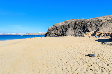 Fototapeta na wymiar View of beautiful Playa de la Cera beach, blue sea, yellow sand, cliffs. Papagayo, Playa Blanca, Lanzarote, Canary Islands, selective focus