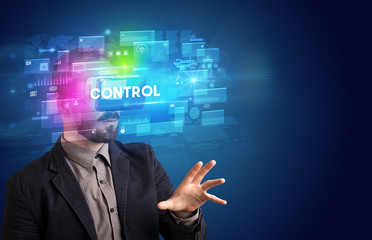 Businessman looking through Virtual Reality glasses with CONTROL inscription, innovative security concept